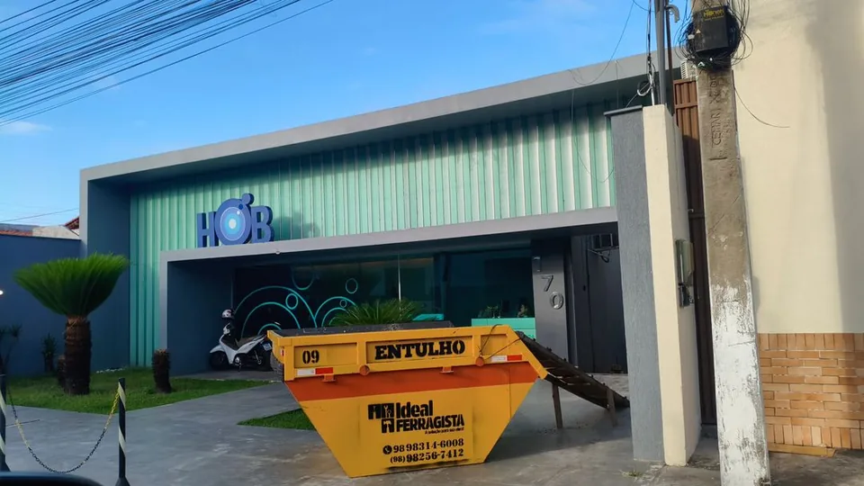 Caçamba de entulho Ideal Ferragista posicionada em frente a um comércio em Santa Inês